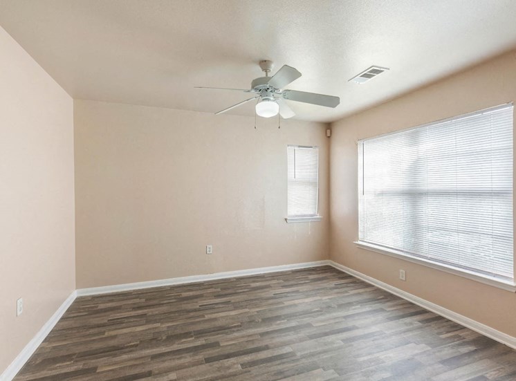Living room with ceiling fan and windows and blinds